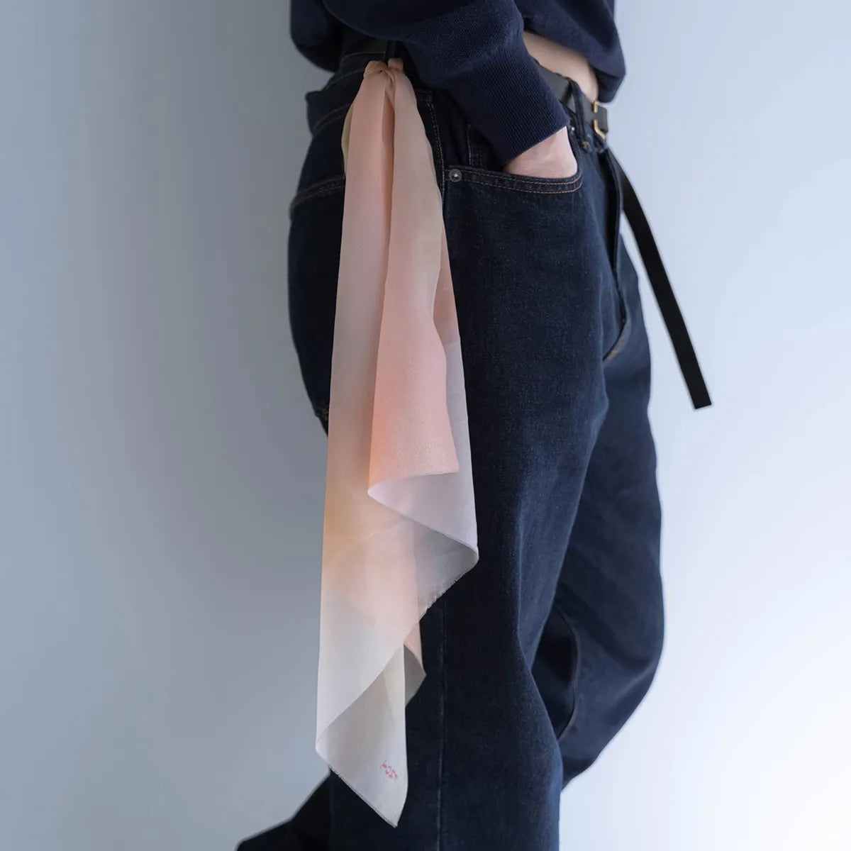 淡い暖色グラデーションのTONEオリジナルスカーフのベルト着用。長さは膝丈までの写真